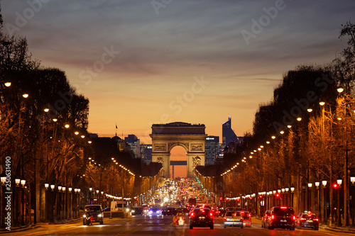 Paris, France - February 13, 2019: Champs Elysees and Arc de Triomphe at sunset with lot of traffic
