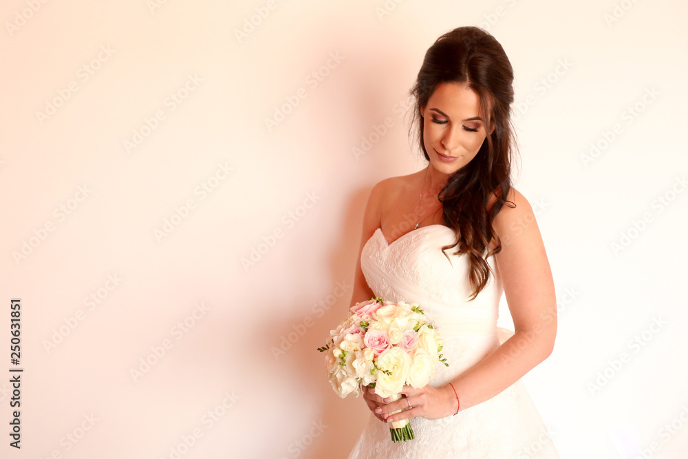 Beautiful bride posing with bouquet of flowers