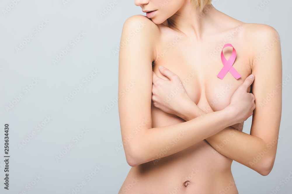 cropped view of beautiful naked girl with pink breast cancer awareness ribbon, isolated on grey cropped view of beautiful naked girl with pink breast cancer awareness ribbon, isolated on grey