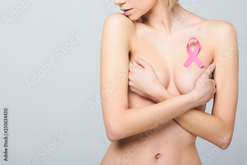 cropped view of beautiful naked girl with pink breast cancer awareness ribbon, isolated on grey