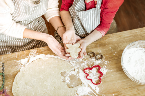 Positive little child carrying unready cookie with her little hands photo