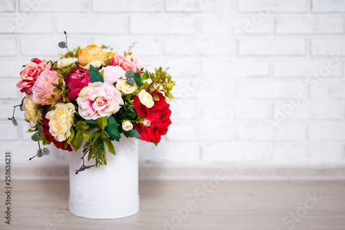 beautiful bunch of summer flowers in round box with copy space over white wall background