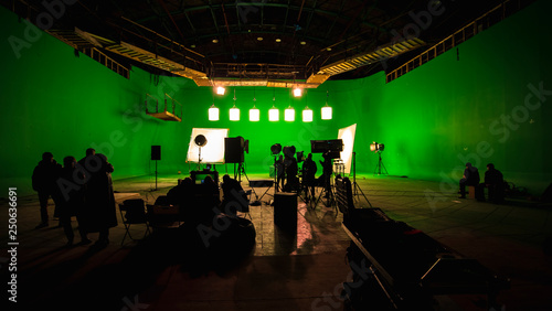 Behind the scenes or the making of film video production and movie crew team working in silhouette of camera and equipment set in studio