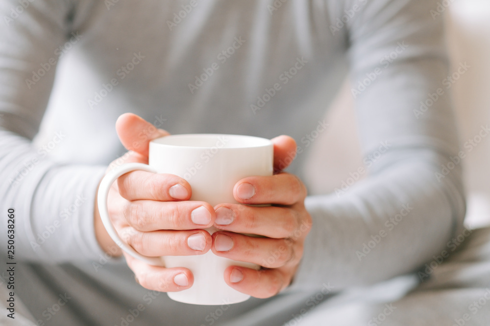 Wake up beverage. Man sitting and holding white cup of hot morning tea. Wake up beverage. Man sitting and holding white cup of hot morning tea.