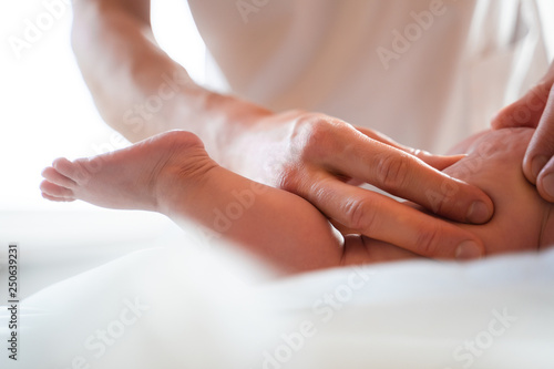 Wallpaper Mural Male masseur doing small child's leg massage, lying on table. Torontodigital.ca
