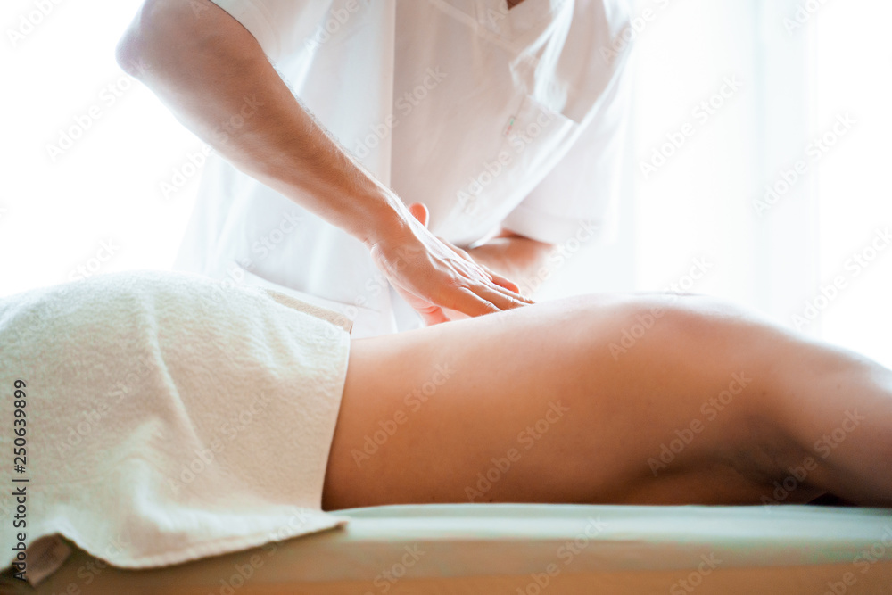 Fototapeta premium Photo from side of male therapist massaging man back.