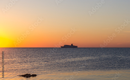 Cruise ship sailing in the sea at sunset 