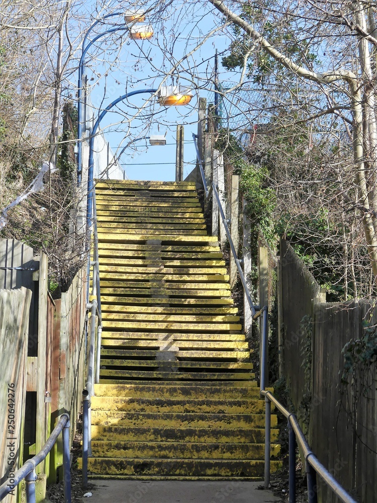 Yellow painted stairs leading to station car park, Chorleywood, Hertfordshire