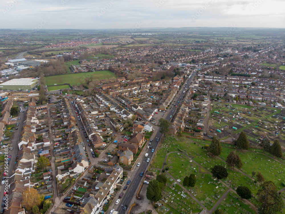 Aerial photo of the town of Aylesbury in the UK showing roads, residential properties, rows of houses and businesses.