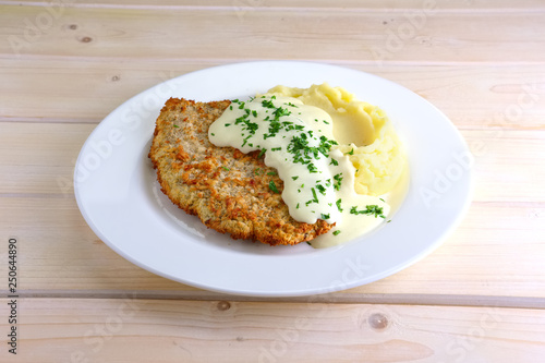 Chopped cutlet in breading with mashed potato and cream sauce