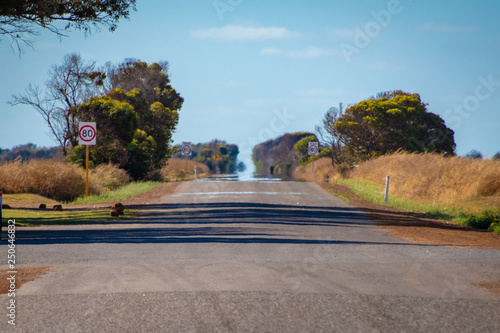 Endless straight road in Australian Outback with hot sun causing a Fata Morgana photo