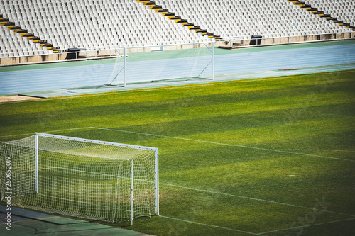 Empty European European football stadium. soccer field with grass and grandstand on a sunny day