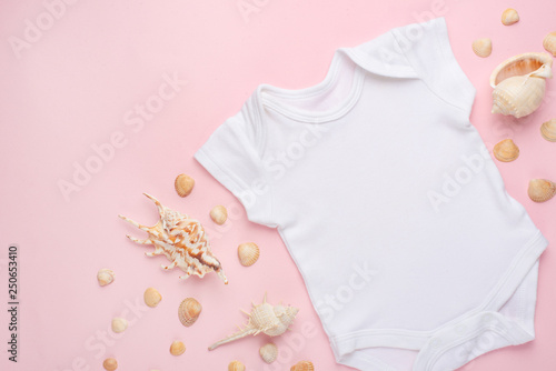 Mockup Flat Lay white baby bodysuit shirt on a pink background with a nautical theme, shells and the sea