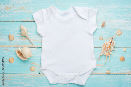 Mockup Flat Lay White Baby Bodysuit Shirt on a Blue Rustic Wood Background with Nautical Seashell, Seashells and the Sea © Anton