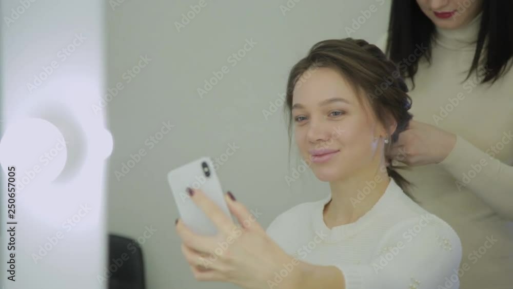 Very beautiful and modern woman makes a selfie when she does her hair in a beauty salon. Very beautiful and modern woman makes a selfie when she does her hair in a beauty salon.
