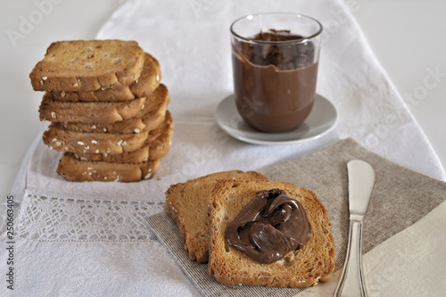 fette biscottate con crema di nocciole al cacao fette sulla tovaglia photo