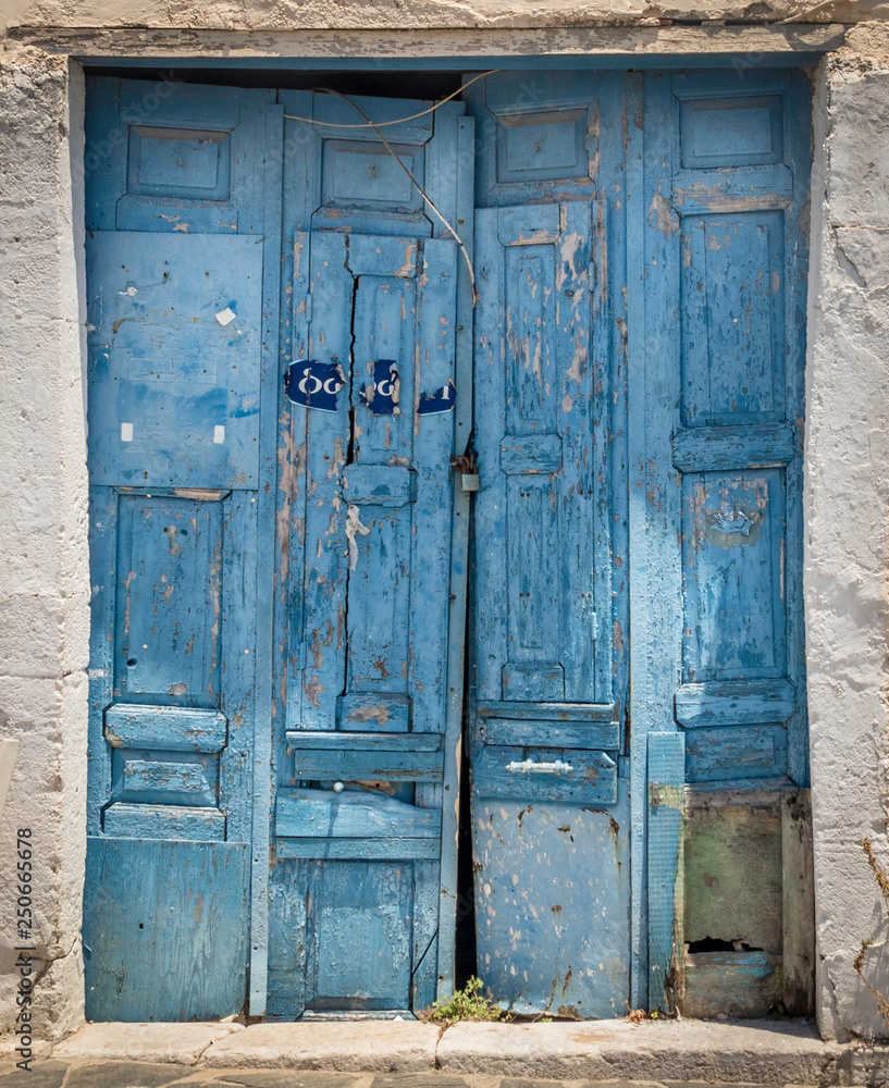 Old wooden doors with weathered blue paint on the village of Potamos on the island of Kythera, Greece