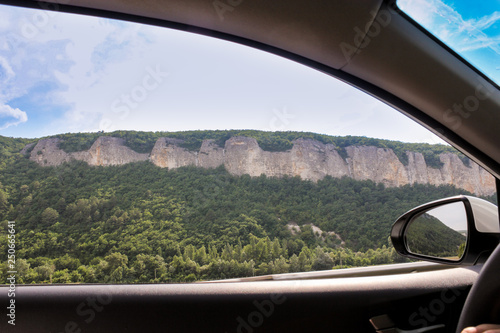 Mountains behind the window of the car.