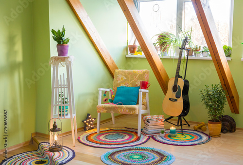 Modern maximalism or maximalist home decor interior design concept, different colorful things in home, vintage chair, flower stand, bright green wall. photo