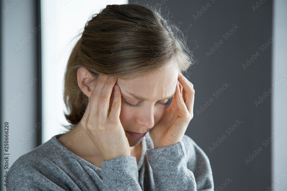 Sick woman at home massaging temples, feeling strong headache Sick woman at home massaging temples, feeling strong headache