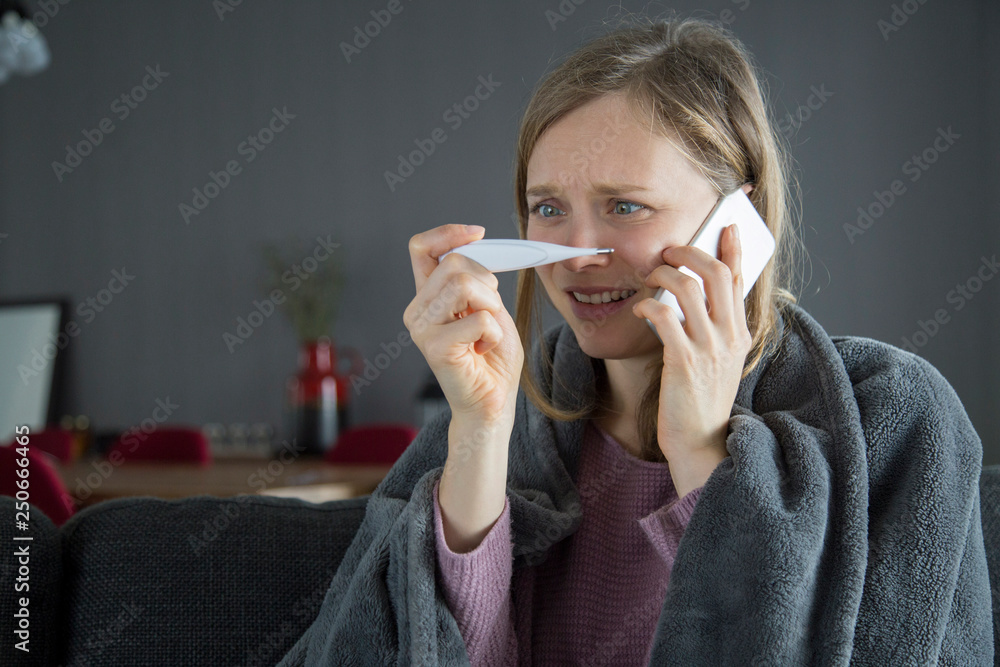 Sick woman calling husband after measuring temperature Sick woman calling husband after measuring temperature