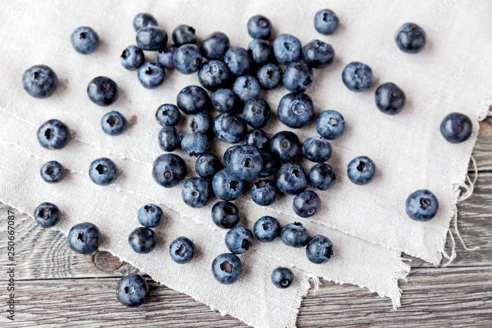 Blueberries lie on homespun tablecloth. Rustic cozy background with healthy food. Fresh-gathered berries full of vitamins, good for diet nutrition and healthy meals. Blueberries lie on homespun tablecloth. Rustic cozy background with healthy food. Fresh-gathered berries full of vitamins, good for diet nutrition and healthy meals.