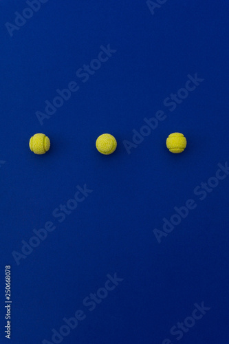 Three tennis balls composition on blue background. Top view. © Create Hot Look