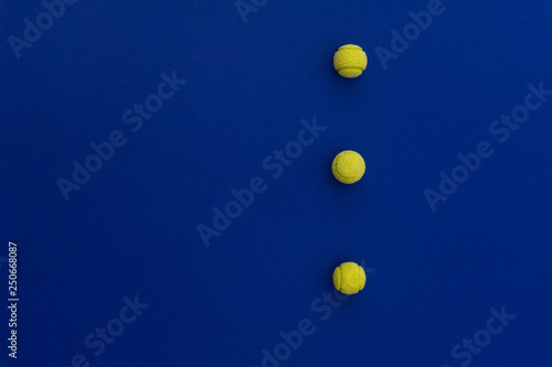 Three tennis balls composition on blue background. Top view. © Create Hot Look