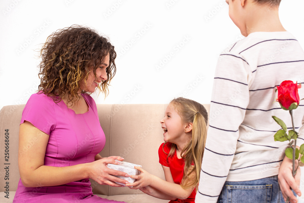 Shot of a mother and her two children holding gift and flower for Mother day or her birthday Shot of a mother and her two children holding gift and flower for Mother day or her birthday
