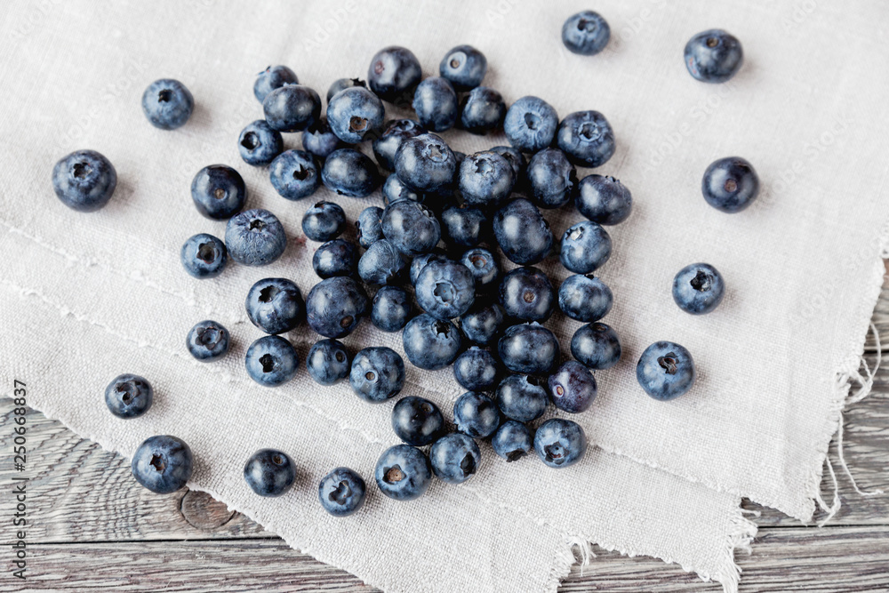 Blueberries lie on homespun tablecloth. Rustic cozy background with healthy food. Fresh-gathered berries full of vitamins, good for diet nutrition and healthy meals. Blueberries lie on homespun tablecloth. Rustic cozy background with healthy food. Fresh-gathered berries full of vitamins, good for diet nutrition and healthy meals.