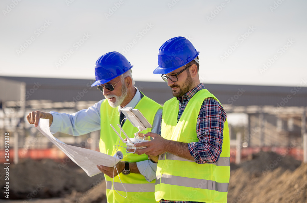 Construction engineers with drone at building site Construction engineers with drone at building site