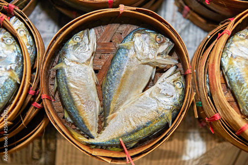 Three common thai mackerel fishes in a woven bamboo basket for sale at the Klong Toey Market in Bangkok, Thailand photo