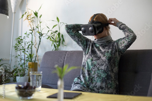 Fototapeta Naklejka Na Ścianę i Meble -  woman at home enjoying virtual reality goggles on sofa