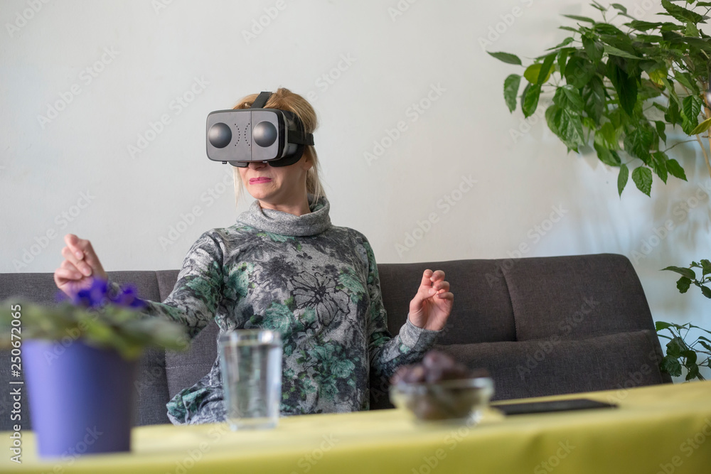 woman at home scared using virtual reality goggles on sofa