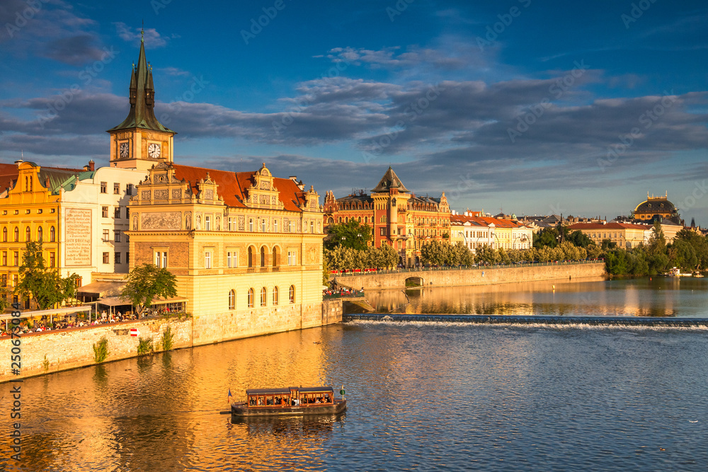 Vltava river and waterfront of the old town with the theater in Prague at sunset, Czech Republic, Europe.