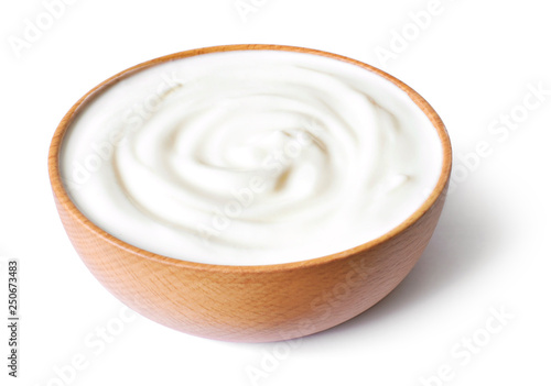 Delicious yogurt scene with wooden bowl, isolated on white background. Closeup shot of healthy fresh yogurt or cream. Top view.