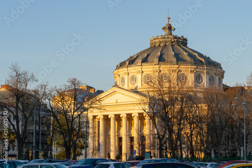 Romanian Athenaeum (Ateneul Roman) in Bucharest, Romania, as seen from across the street, at sunset, with warm light across its front columns. This is the city's main concert hall.