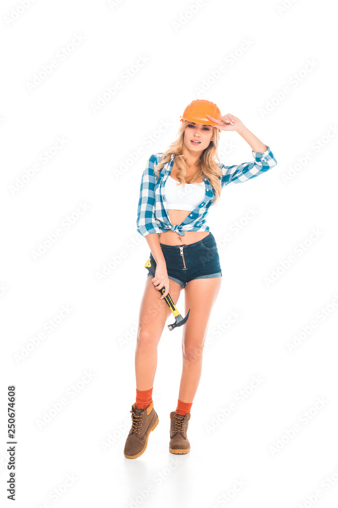 blonde handy woman in blue shirt, shorts and orange hardhat standing with hammer on white background blonde handy woman in blue shirt, shorts and orange hardhat standing with hammer on white background