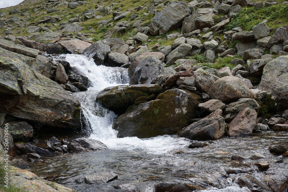 Bachlauf/ kleine Wasserfälle über Steine in den Bergen