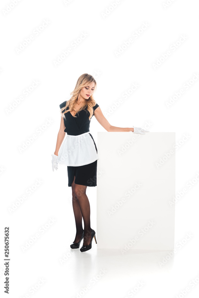 attractive housemaid in black uniform, apron, stockings standing with empty placard on white background attractive housemaid in black uniform, apron, stockings standing with empty placard on white background