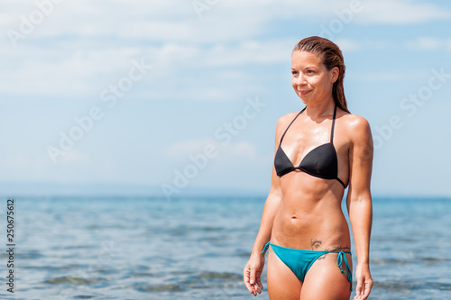 Young woman in a bikini wet from swimming in the sea