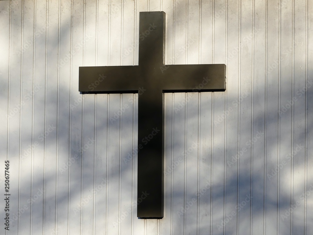 Christian cross on white outside wall of church