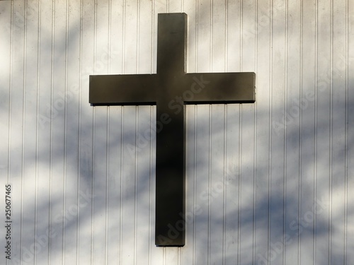 Christian cross on white outside wall of church