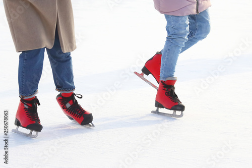 Feet of people skating on a street ice rink