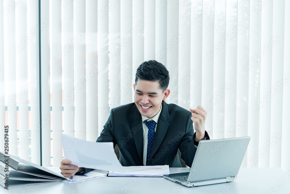 Young asian employee working at laptop during working day in office,Businessman happy with smile in the office,thailand people at company Young asian employee working at laptop during working day in office,Businessman happy with smile in the office,thailand people at company