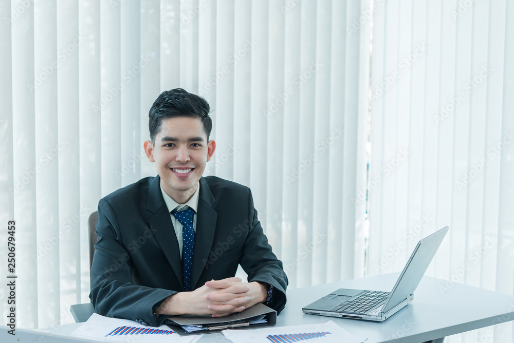 Young asian employee working at laptop during working day in office,Businessman happy with smile in the office,thailand people at company Young asian employee working at laptop during working day in office,Businessman happy with smile in the office,thailand people at company