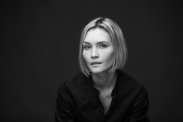 Dramatic black and white portrait of a beautiful woman on a dark background