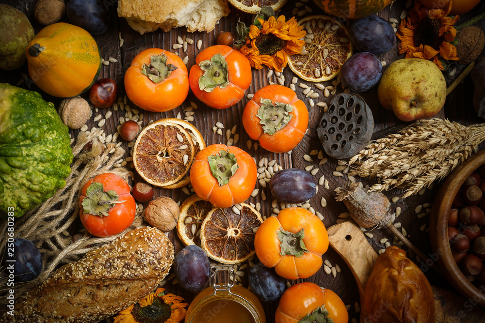 Pumpkins, persimmon, cereals, bread, seeds and nuts on a wooden background, Harvest, Autumn Pumpkins, persimmon, cereals, bread, seeds and nuts on a wooden background, Harvest, Autumn