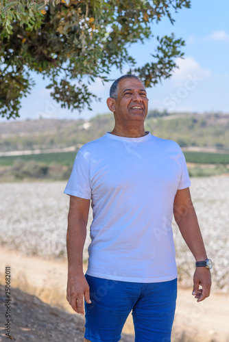 Portrait Of Handsome Old Active Senior Man Outdoors. Sporty athletic elderly businessman on nature background. Senior farmer standing in meadow background.