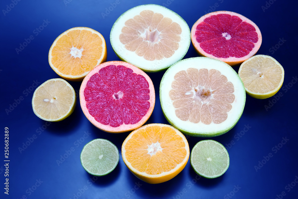 cut pieces of different citrus fruits on dark background cut pieces of different citrus fruits on dark background